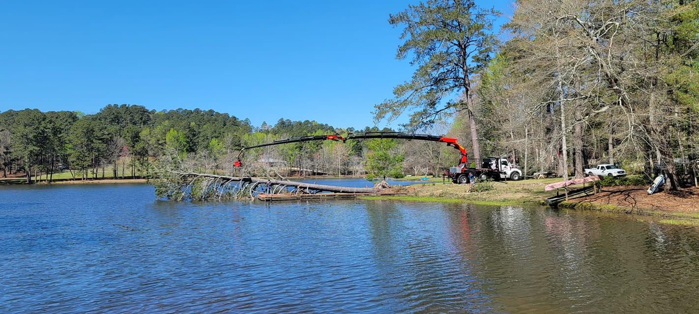 Morgan's Tree Service, LLC crane removing fallen tree from water.